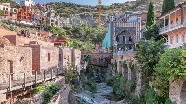 Abanotubani district in Old Tbilisi, Georgia where most of the Sulphur baths are located aerial timelapse. River and waterfalls aerial view near waterfall square