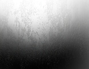 Close-up of a fogged glass window with water droplets creating a textured abstract pattern in grayscale