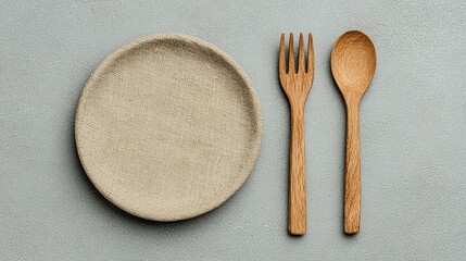 Simple wooden fork and spoon on a light beige plate.