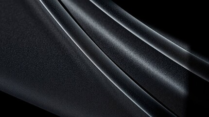 Closeup of textured black fabric folds with light reflection on raised areas