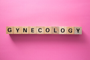 Gynecology word written with wooden cubes on pink background