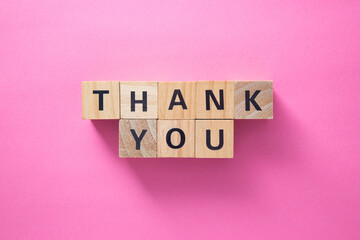Thank you message on wooden cubes on pink background