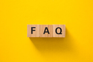Wooden cubes showing faq acronym on yellow background