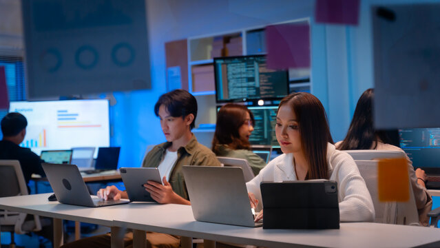 Asian software engineer or programmer team working late in development office,problem solving or algorithm of ai assistant helping for work.software developer,digital technology security concept