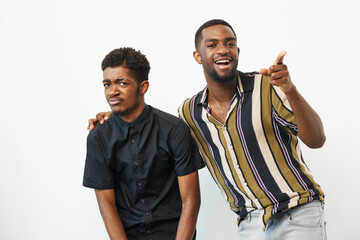 Two African American men enjoying a fun moment together, one smiling broadly while the other feigns...