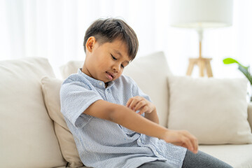 Fototapeta premium Young asian boy concerned expression itch or skin irritation, children allergy, particularly those related to skin care and health, childhood, health, skin care and medical attention daily life