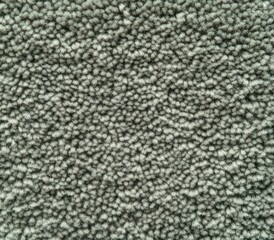 Close-up texture of a dense, looped green carpet fibers showing soft and tightly packed surface