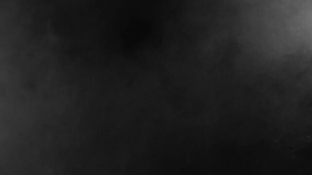Very subtle dark grey fog or smoke drifts gently across black background. Eerie and mysterious atmospheric overlay for suspenseful scenes