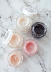 Bowls with various colorful cream beauty products on marble background.
