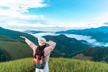 Young woman travelers looking at the sunrise and the sea of mist on the mountain in the morning, Travel lifestyle concept