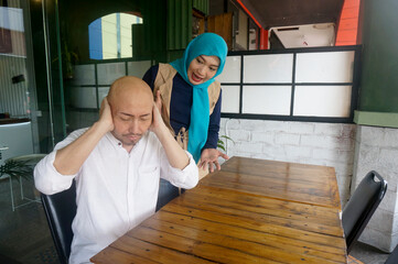 Young Asian Couple Arguing In Restaurant. Emotional Woman Shouting At Man, Blaming Him For...