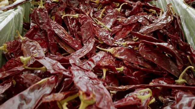 Pull out shot of crushed guajillo chili in some baskets during the day, handheld shot
