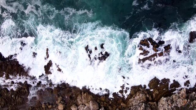 Atlantic ocean waves smashing into rugged rocky coastline. Drone top down slider