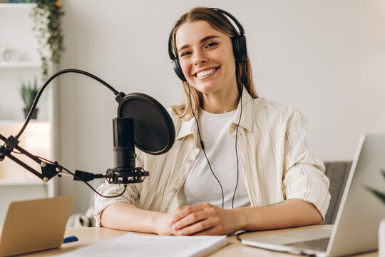 Young woman recording a podcast from her home studio
