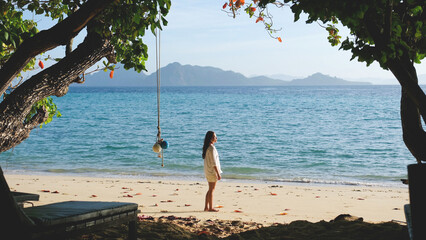 Portrait of a woman with white shirt standing on the beach
