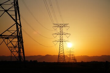 Power Lines at Sunset Silhouette Against Golden Sky Energy Infrastructure Transmission Towers