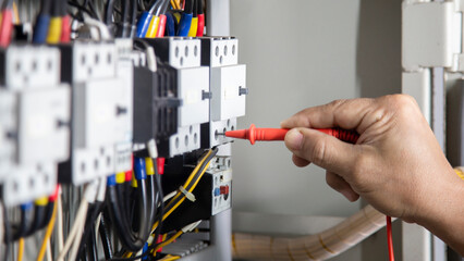 Electrical engineers use multimeter to check electrical installations in electrical control...