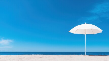 summer concept. Sunny beach with a white umbrella and clear blue skies.
