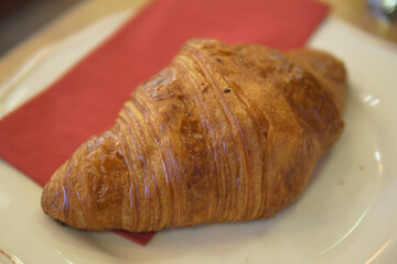 Freshly baked croissant on a plate at a cafe