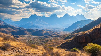Stunning mountain landscape showcasing dramatic peaks under a bright sky filled with clouds, bathed in warm sunlight, perfect for nature enthusiasts.