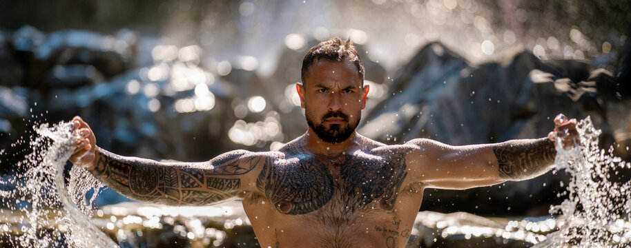 Strong man. Muscular body. Healthy muscular male body under waterfall. Strong man splashing in nature. Fit and sexy male torso. Athletic body. Physical strength and wellness. Man beauty, body balance.