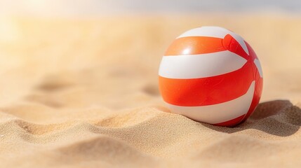 summer concept. Colorful beach ball resting on sandy shore under bright sunlight.