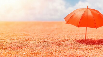 summer concept. Bright orange umbrella on a sandy beach under a clear sky.