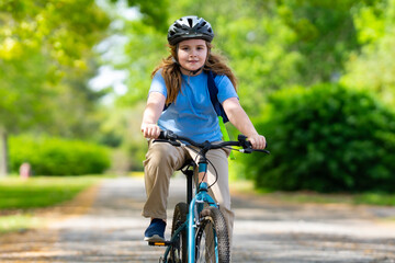 Child bike ride. Teen boy biking down summer road. Kid riding bicycle with smile. Child cycling. Kid ride on bike. Happy boy on bike. Child biking outdoors. Children biking. Little biker.