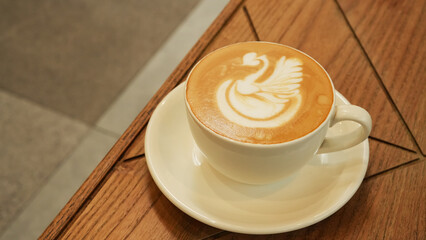 A cup of hot latte coffee on the table for breakfast
