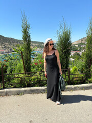 A girl in a hat walks by the sea