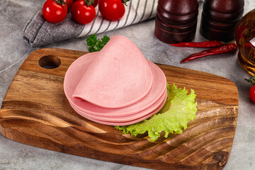 Sliced boiled sausage over board