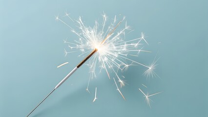 Obraz premium Burning sparkler on a light blue background festive celebration