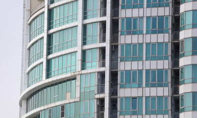 A tall building with many windows and a blue tint