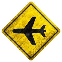 Yellow warning sign with black airplane icon and aged texture on white background.