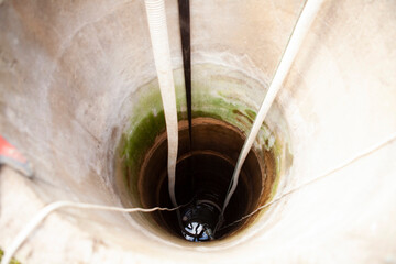 Cleaning a rural concrete well: The first stage involves pumping out all the water to the very bottom. This allows access to the well s base for thorough cleaning and sediment removal.
