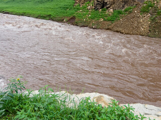After heavy rain, the flood water from the highlands flows into the river. The water is muddy and has lots of wood chips and other things.