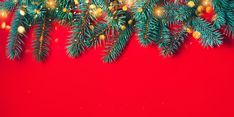 Fir branches on red background. Christmas wallpaper. Flat lay, copy space.