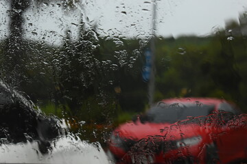 red car on parking in raining day, abstract blur background