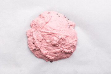 Overhead view of strawberry and chocolate sourdough on a white parchment paper, top view of pink and chocolate artisan bread dough  on a white background, high hydration bread dough on parchment paper