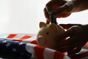 Closeup view of an American flag with a pink piggy bank for various financial concepts.