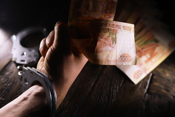 Handcuffs behind, five thousand rubles. Concept of corruption