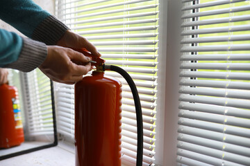 hand presses the trigger fire extinguisher available in fire emergencies conflagration damage...