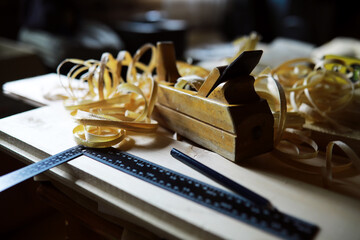Plane jointer carpenter or joiner tool and wood shavings. Woodworking tools on wooden table. Carpentry workshop