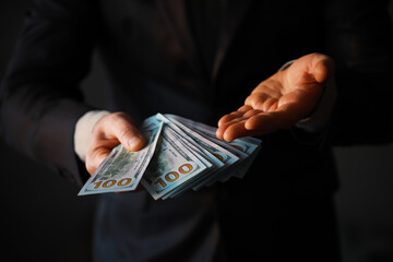 Business Man Displaying a Spread of Cash over a gray vintage background