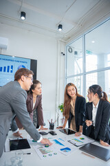 Group of confident professional business people pointing at graphs and charts to analyze marketing...