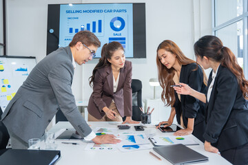 Group of professional business people or accountants working together on financial investment on calculator, doing calculation, analyzing business growth and marketing on graph in modern office.
