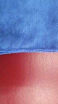 Close-up texture of blue fabric contrasted against a red leather surface.