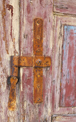 Close up of an old door with peeling paint, showing the wood grain texture