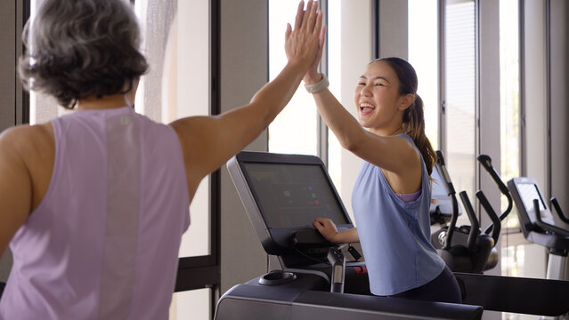 Young active adult child and mature middle age old mum run walk advice workout at gym. Love mental health care older retired mom asia elder people happy protect aging life balance enjoy sport club.