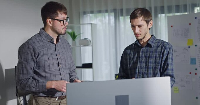 Team adult male engineer collaborate on robotic hand project using AI code solutions machine learning at tech workspace. Artificial intelligence interface, collaboration support prototype development.